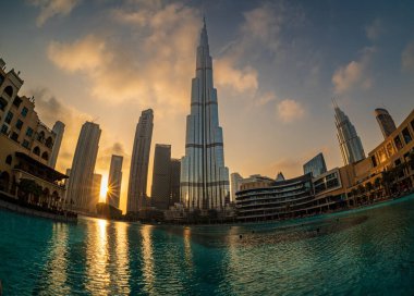 Burj Khalifa Gölü yakınlarındaki Dubai şehir merkezinin ufuk çizgisinde gün batımı ve güneş doğumu