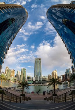 Yüksek apartman bloklarının ve otellerin BAE 'deki Dubai Marina' daki su kenarındaki balık bakışı manzarası