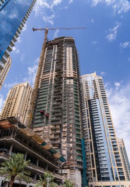Vinçler ve bina, BAE 'deki Dubai Marina rıhtımının etrafındaki yeni apartman blokları etrafında çalışıyor.