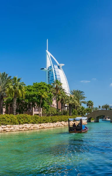 在迪拜的Souk Madinat Jumeirah附近的水道上划船游览 背景是标志性的阿拉伯酒店 — 图库照片
