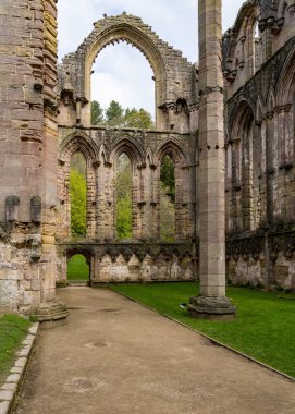 Detail of the ruins of Fountains Abbey in Yorkshire, United Kingdom in the spring with focus on the large altar window clipart