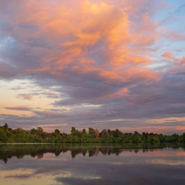 Shropshire, Ellesmere 'de mükemmel bir göl yansıması olan Mere kıyısının günbatımı manzarası.