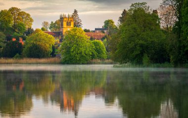 Shropshire 'daki Ellesmere kasabasının günbatımı manzarası Mere' den Kiliseye yansıyor.