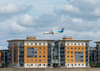 Woolwich, Londra - 15 Mayıs 2023: Luxair uçağı şehir havaalanına inmek için apartman bloğunun üzerinden alçaktan uçuyor