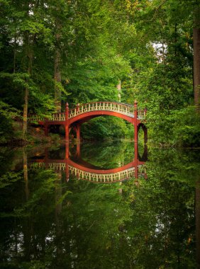 Williamsburg Virginia 'daki William ve Mary Koleji' nin kampüsündeki Crim Dell göletinin üzerindeki ahşap köprüyü süsleyin.