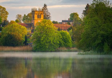 Shropshire 'daki Ellesmere kasabasının günbatımı manzarası Mere' den Kiliseye yansıyor.