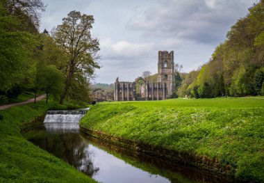 İlkbaharda Yorkshire, İngiltere 'de bulunan ve Skell Nehri' nin aktığı Fountains Abbey harabelerinin detayları