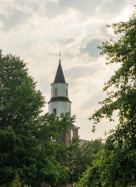 日の出の暖かい日差しがウィリアムズバーグのブルートン教区教会のレンガと木製の塔を照らす — ストック写真