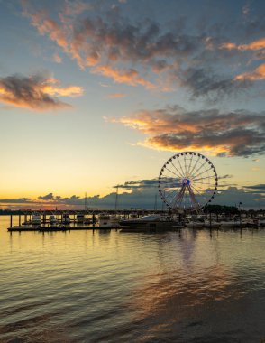 Washington DC 'nin başkenti yakınlarındaki National Harbor' da gün batımında yat limanında parlayan dönme dolap.