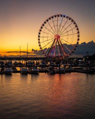 Washington DC 'nin başkenti yakınlarındaki National Harbor' da gün batımında yat limanında parlayan dönme dolap.