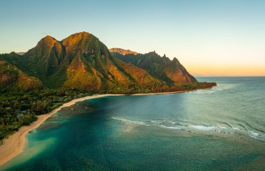 Sabahın erken saatlerinde Hawaii 'nin Kauai Adası' ndaki Kauai adasındaki tünellere hakim olan dağları yakalayan hava panoramik görüntüsü ve Na Pali dağları.