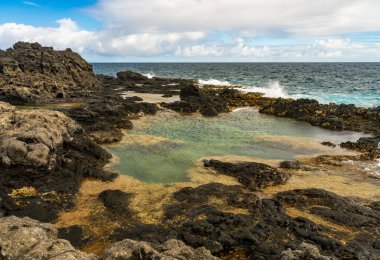 Kauai 'nin kuzey kıyısındaki Kilauae noktasının yakınındaki lav kayaları üzerinde gelgit havuzları.