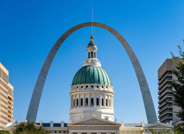 St. Louis Missouri 'deki eski adliyenin kubbesi mavi gökyüzüne karşı ve binayı çevreleyen ünlü geçit kemerine karşı.