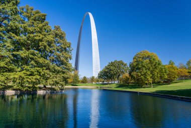 St. Louis Missouri 'deki Ulusal Geçit Parkı' ndaki mavi gölün karşısından St. Louis Kemeri 'ne sakin suda yansıyan görüntüyü göster.