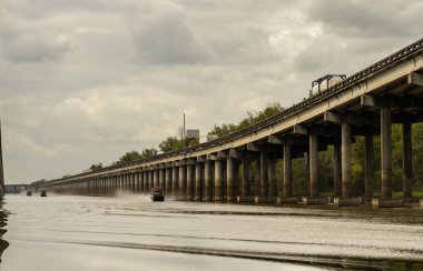 Baton Rouge Louisiana yakınlarındaki Atchafalaya Havzası üzerindeki I-10 eyaletler arası köprüler boyunca seyahat eden bataklık tekneleri.