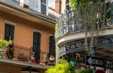 Royal Caddesi 'ndeki geleneksel New Orleans binasına gri işlemeli demir balkonları olan sepetler asıyorlar.