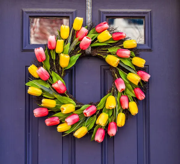 在外门的圆形花环中排列郁金香 标志着复活节和春天的开始 免版税图库图片