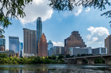 Austin, TX - 15 Haziran 2024: Austin Texas 'taki Güney Kongresi köprüsünden Colorado Nehri kıyısındaki modern binaların ve ofislerin panoraması