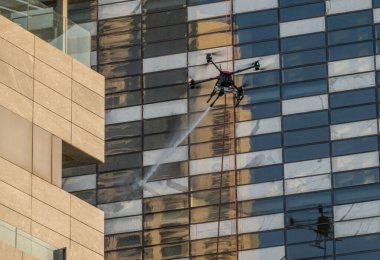 Amman, Ürdün 'deki modern ofis binasında yangın söndürme egzersizi sırasında drone' lar su püskürtüyor.