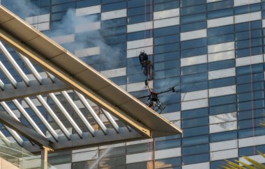 Amman, Ürdün 'deki modern ofis binasında yangın söndürme egzersizi sırasında drone' lar su püskürtüyor.