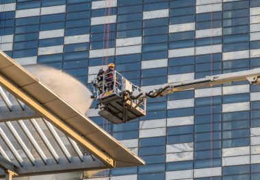 İtfaiyeciler, Amman, Ürdün 'deki modern ofis binasında yangın söndürme tatbikatı sırasında su püskürtüyor.