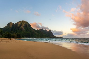 Hawaii, Kauai adasında şafak vakti güzel tüneller kumsalında ıslak kumlara yansıyan titrek gökyüzü.