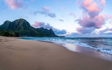 Hawaii, Kauai adasında şafak vakti güzel tüneller kumsalında ıslak kumlara yansıyan titrek gökyüzü.