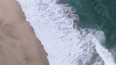 Hawaii 'nin Kauai adasındaki Hanalei' de dalgaların ve dalgaların yukarıdan aşağıya doğru yuvarlanışının dikey görüntüsü.
