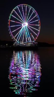 Günbatımında Washington DC 'nin başkenti yakınlarındaki National Harbor' da yanan dönme dolap.