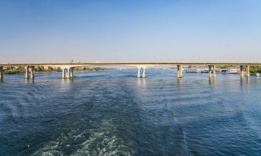 Nil 'in doğu ve batı kıyılarını Luxor' a bağlayan modern köprüden nehrin yukarısına giden bir tekne.