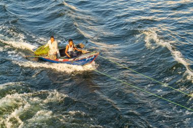 Luxor, Mısır - 2 Kasım 2024: Küçük tekneli iki adam akarsu yoluyla köye götürülüyor