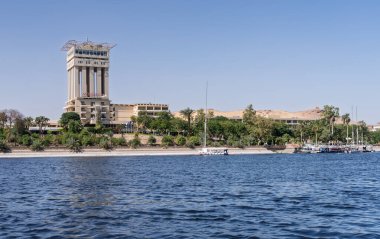 Aswan, Mısır - 4 Kasım 2024: Fildeki Movenpick Oteli, Nil kıyısında. Felluca tatil köyüne yanaştı.
