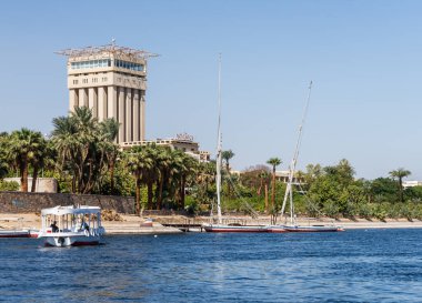 Aswan, Mısır - 4 Kasım 2024: Fildeki Movenpick Oteli, Nil kıyısında. Felluca tatil köyüne yanaştı.