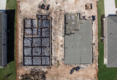 İki inşaat alanının yukarıdan görünüşü, biri beton kaplama ve diğeri de beton için hazır bir çerçeve.