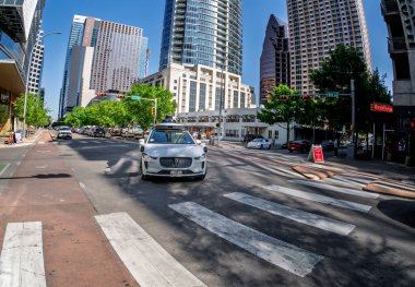 Austin, TX - 10 Nisan 2025: Waymo Jaguar otonom taksisinin Teksas şehir merkezindeki kavşakta dönüşünün Fisheye mercek görüntüsü
