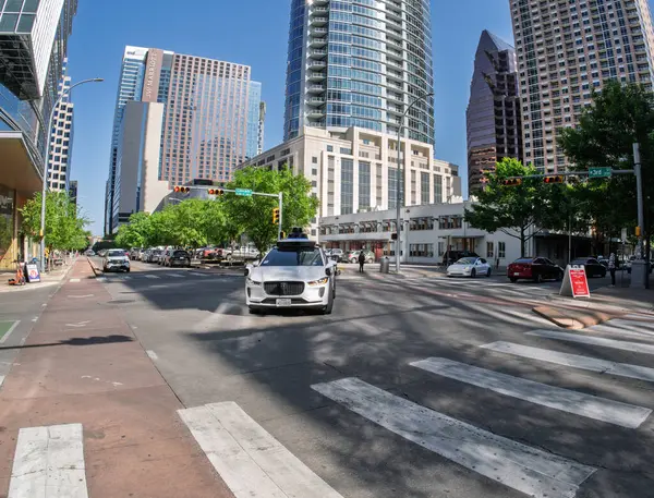 Austin, TX - 10 Nisan 2025: Waymo Jaguar otonom taksisinin Teksas şehir merkezindeki kavşakta dönüşünün Fisheye mercek görüntüsü