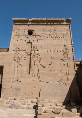 Isis ve Horus 'un Mısır' daki Aswan Limanı 'nda yeniden inşa edilen the Aswan Tapınağı' nda Firavun 'a bakan levrek yardım oymalarının ayrıntıları.