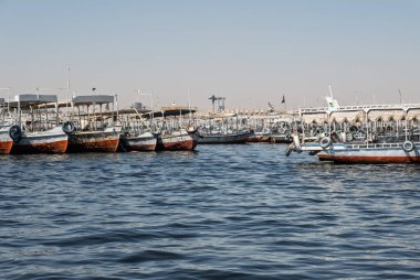 Eski Aswan barajı yakınındaki turistlerin çoğu turist nakletmekte kullanılan tur tekneleri ve feribotları ile