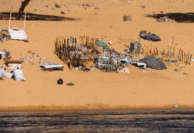 Aswan yakınlarındaki Nubian köyünde Nil Nehri kıyısındaki kumlu sahilde Mısır hediyeleri ve ıvır zıvır koleksiyonu.