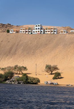 Mısır yakınlarındaki Nil Nehri 'nin hızlı akan suları ve tepedeki Nubia tatil beldesi.
