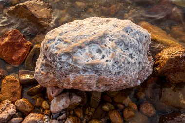 Yakından bakınca, ölü denizin kenarındaki kayaların üzerinde bulunan eşsiz tuz oluşumlarının güneş ışığında parladığını görüyoruz.