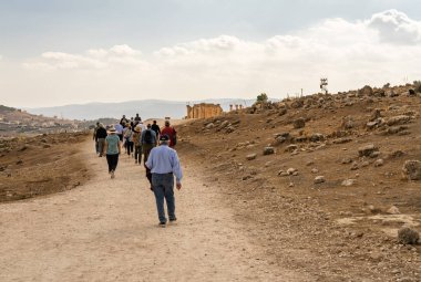 Ürdün 'de iyi korunmuş bir Greko-Romen kenti olan Jerash' taki anıtlar arasında yürüyen turistler