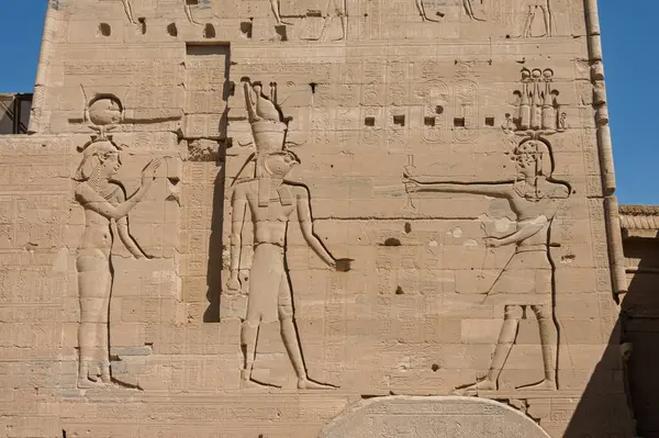 Isis ve Horus 'un Mısır' daki Aswan Limanı 'nda yeniden inşa edilen the Aswan Tapınağı' nda Firavun 'a bakan levrek yardım oymalarının ayrıntıları.