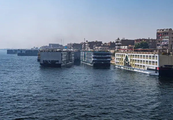 Edfu 'da kalabalık bir liman, Nil yolcu tekneleri yanaştı ve diğerleri Mısır' daki Aswan nehrinden ayrılıyor.