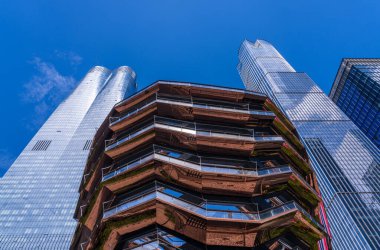 Hudson Yards 'da eşsiz bir bal peteği şekilli halk simgesi olan Gemi, kabarık bulutlu, parlak mavi bir gökyüzünün altında duruyor.