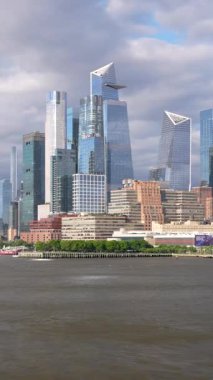 Hudson Nehri 'nden geçen gemiden Manhattan şehir merkezindeki Hudson Yards ve Hells Kitchen' ın modern siluetinin dikey görüntüsü.