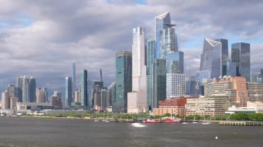 Hudson Yards ve Hells Kitchen 'ın modern ufuk çizgisi üzerinde yavaş pan Manhattan şehir merkezinde Hudson Nehri' nden aşağı giden gemiden