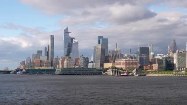 Hudson Yards ve Hells Kitchen 'ın modern ufuk çizgisi üzerinde yavaş pan Manhattan şehir merkezinde Hudson Nehri' nden aşağı giden gemiden