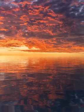 Sakin suyun üzerinde görülen dramatik ve görkemli günbatımı okyanus yüzeyindeki dalgalanmalara yansıdı.