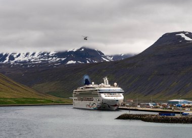 Isafjordur, İzlanda - 27 Mayıs 2025: Norveç Star yolcu gemisi limana yanaştı Sahil Güvenlik helikopteri tepemizde